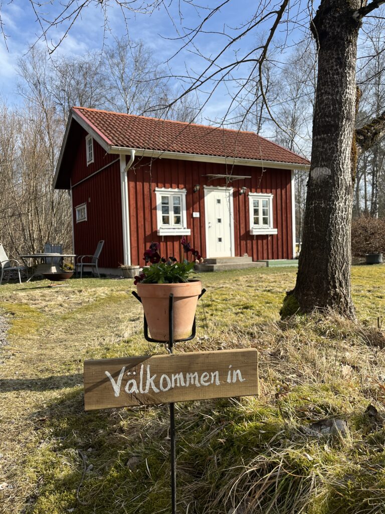 Naturlig läkningsmottagning är en rödstuga. Välkommenskylt med blomkruka